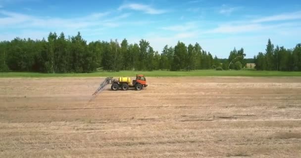Traktoranhänger zum Sprühen von Düngemitteln bewegt sich auf abgeerntetem Feld — Stockvideo