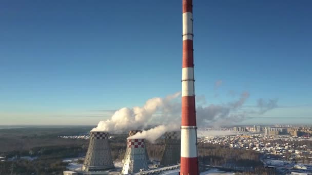 Повітряний вигляд димоходу і башти охолодження проти міста і неба — стокове відео