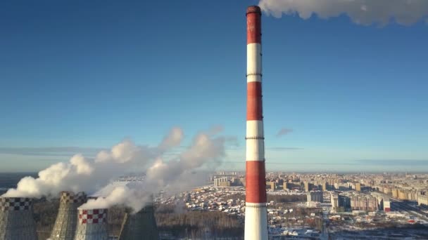 Luftbewegung vorbei an Schornstein und Kühltürmen gegen die Stadt — Stockvideo