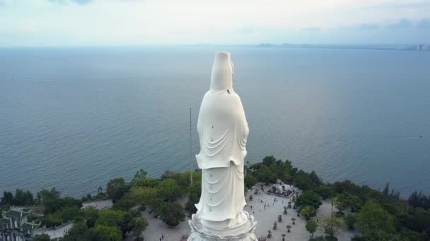 Ανώτερο γύρο κίνησης τεράστιο λευκό άγαλμα του Βούδα στην ακτή του ωκεανού — Αρχείο Βίντεο