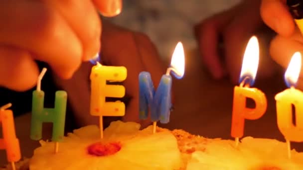 Slow motion close-up mensen licht feestelijke kaarsen op taart — Stockvideo