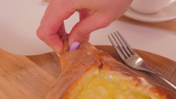 Closeup hand takes bread piece puts into khachapuri filling — Stock Video