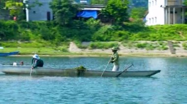 Yerel halkın float yeşil banka tarafından kürek ile nehir tekne