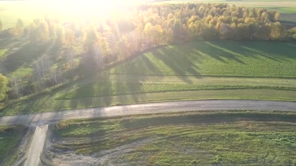 Vista aérea campos vazios cruzados por estradas contra a luz solar — Vídeo de Stock