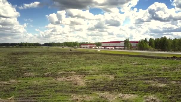 Luchtfoto beweging boven veld bedekt met groene en droog gras — Stockvideo