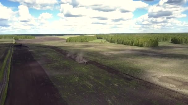 Minivan aéreo se coloca en la carretera entre campos con tractor — Vídeo de stock