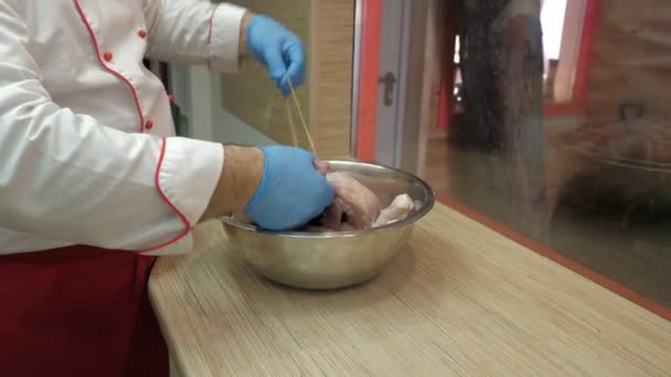 Cerrar vista cocinar vientos encaje alrededor de las piernas de pollo y alas — Vídeos de Stock