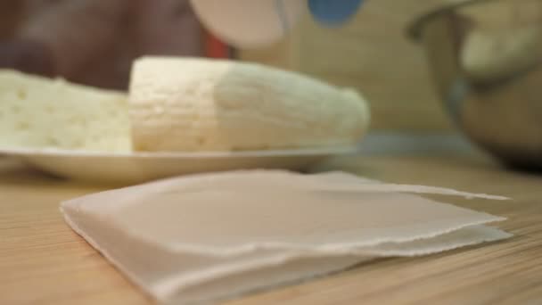 Nahaufnahme Koch legt Ei auf weiße Serviette auf Holztisch — Stockvideo