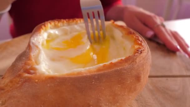 Closeup woman mixes egg and cheese in khachapuri hole — Stock Video