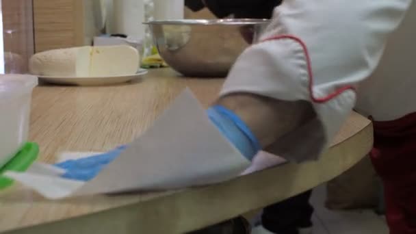 Κλείστε την προβολή μάγειρας σκουπίζει ξύλινο τραπέζι με λευκή πετσέτα — Αρχείο Βίντεο