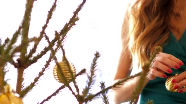 Frau hängt goldene Kugeln in Zeitlupe an Weihnachtsbaum — Stockvideo