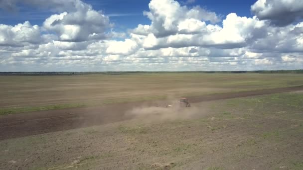 Vecchio trattore erpici terreno campo grigio circondato da nubi di polvere — Video Stock