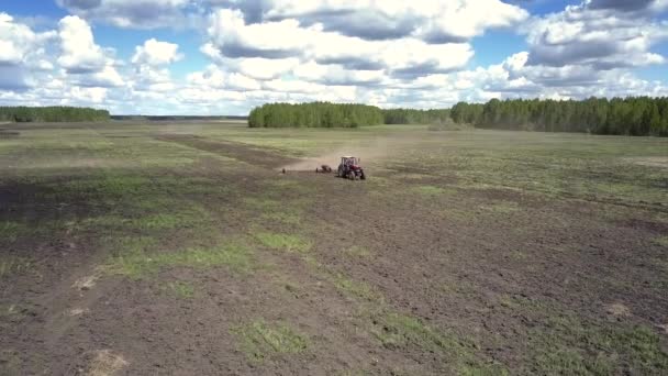 上部のビュー トラクター塵雲の広いハーロウで土を耕す — ストック動画