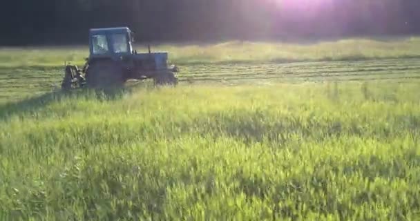 Машина с приводами косилки быстро вдоль большого зеленого поля — стоковое видео
