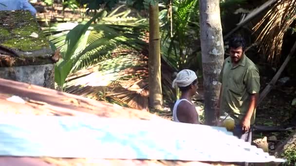 Lavoratori con taglio di cocco e sigaretta passeggiano lungo le palme — Video Stock