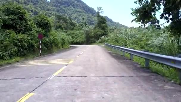 Carretera de montaña con barrera y rayas blancas contra colinas — Vídeos de Stock