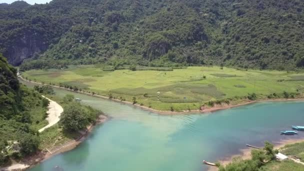 Luftbewegung über Fluss mit Touristenboot, das zur Höhle segelt — Stockvideo