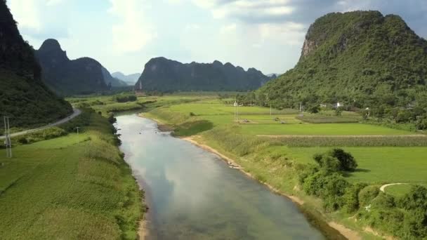 Moto aereo sopra i campi di attraversamento del fiume tra le montagne — Video Stock