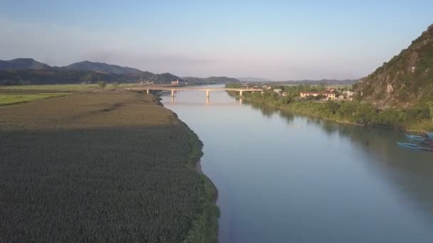 De rivier van de lucht mening tussen kleine stad en groene pinda gebieden — Stockvideo