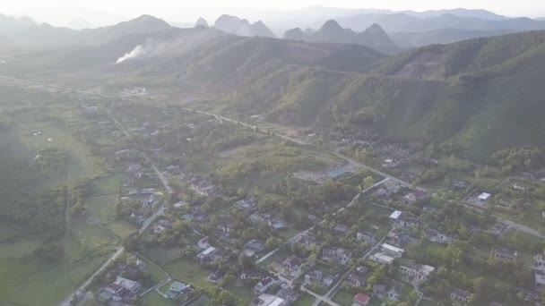 Vista aérea pueblo de las tierras altas con carreteras cerca de un pequeño lago — Vídeo de stock