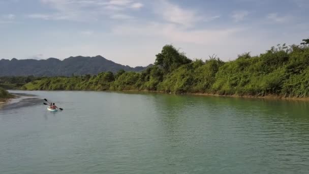 Légifelvételek turisták csónakkal sor evező közelében dombos Bank — Stock videók
