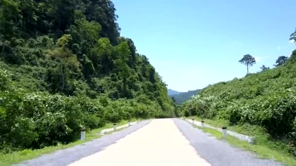 Carretera de montaña con señal amarilla de camino negro bajo el cielo despejado — Vídeos de Stock