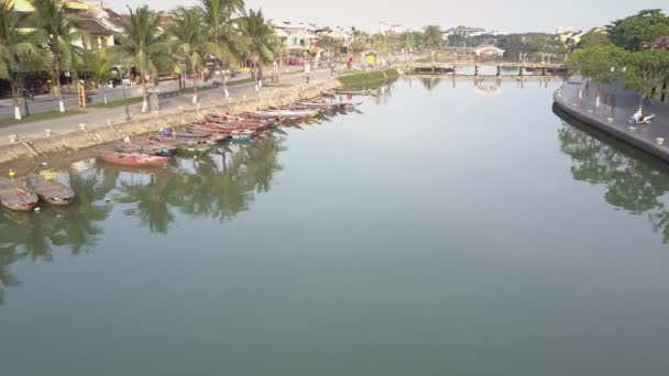 Воздушное движение над рекой с причалом лодок по набережной — стоковое видео