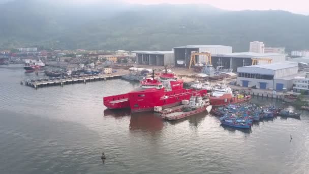 Barcos coloridos y barcos amarran en el muelle contra el almacenamiento de pescado — Vídeo de stock