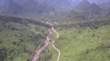 sığ dağ nehri boyunca dar asfalt yol rüzgarları