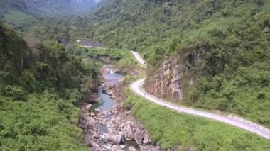 berrak sığ nehir yakınındaki tepe ayak boyunca asfalt yol rüzgarları