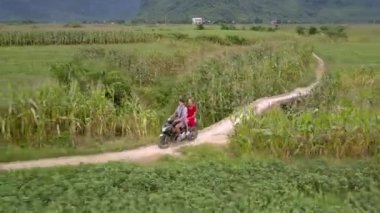 adam zemin yol boyunca arka koltukta kız ile scooter sürmek