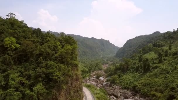 Estrecho camino de asfalto curvas a lo largo de pie de colina cerca del río — Vídeo de stock