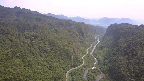 Forêt tropicale verte s'élève sur de hautes collines au-dessus de la route asphaltée — Video