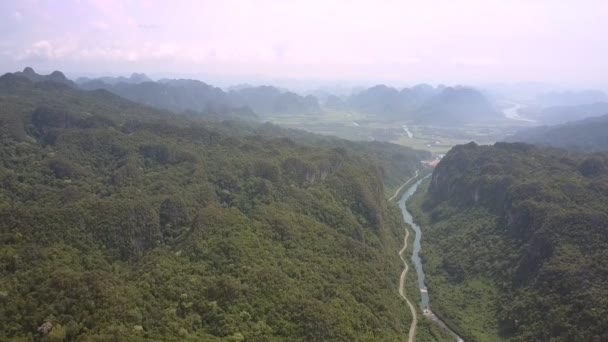 Niebla ligera se encuentra sobre el estrecho río de montaña cerca de la carretera curva — Vídeo de stock