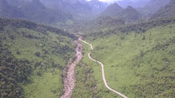 Ruisseau de montagne peu profond coule le long de la route étroite courbe — Video