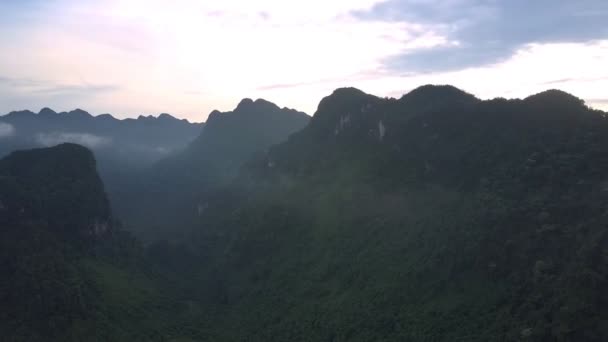 Picos de montaña entre niebla y colinas cubiertas de bosque verde — Vídeos de Stock