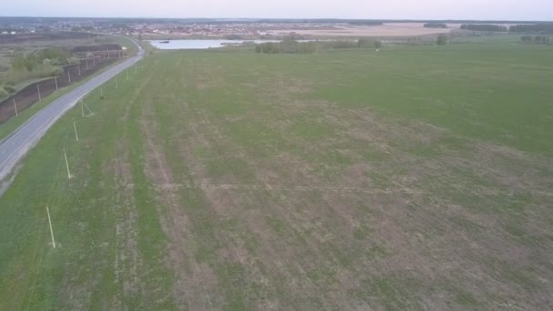 Ruch nad autostradą przez nieograniczone pole do maleńkiego błękitnego jeziora — Wideo stockowe