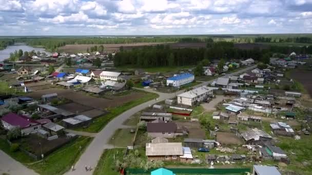 Village with coloured house roofs against green forest — Stock Video