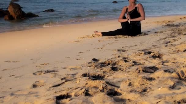 Schöne Brünette im schwarzen Anzug sitzt beim Meditieren — Stockvideo