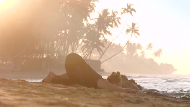 Прекрасная дама фиксирует йогу поза рядом с океаном волны вид снизу — стоковое видео