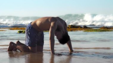 sonsuz okyanus yakınında yakışıklı sporcu uygulamaları yoga