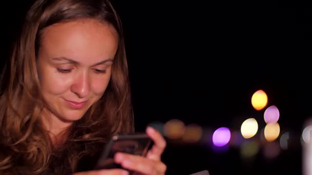 Гарна леді сидить зі срібним телефоном в руках і чатах — стокове відео