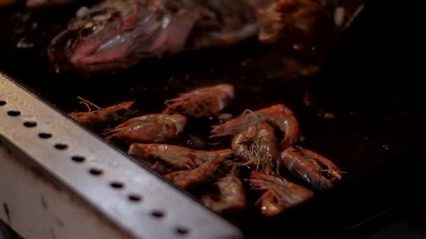 Смажена сковорода з великою рибою біля смачних креветок та олії — стокове відео