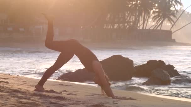 Tremendous girl in black tracksuit raises leg in yoga pose — Stock Video