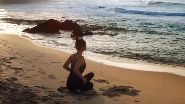 Wonderful girl sits in relaxing yoga pose backside view — 비디오