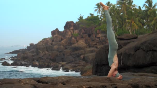 女人做头站在平坦的石头靠近海洋慢动作 — 图库视频影像