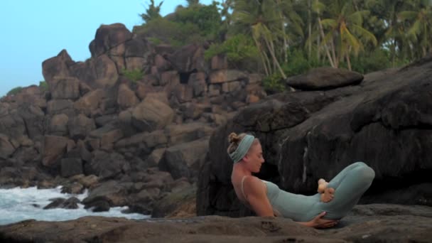 Profesor de yoga se mete en padma matsyasana en cámara lenta orilla — Vídeo de stock