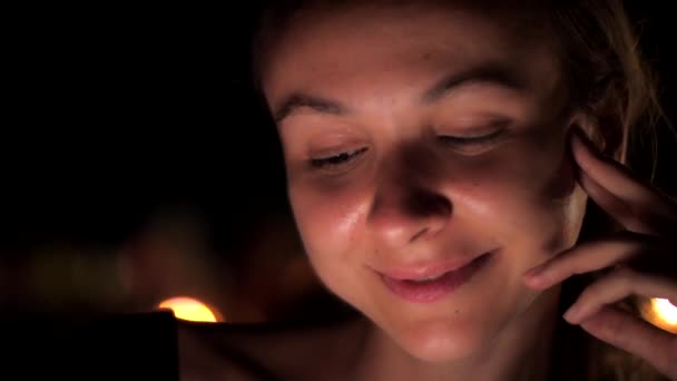 Молода леді з натуральним макіяжем і віями сидить вночі — стокове відео