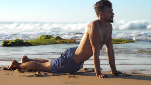 Muskuløs mand med skæg trækker vejret dybt i yoga position – Stock-video