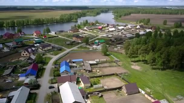 Modernes Dorf in der Nähe von blauem ruhigen Fluss und braunen Feldern — Stockvideo